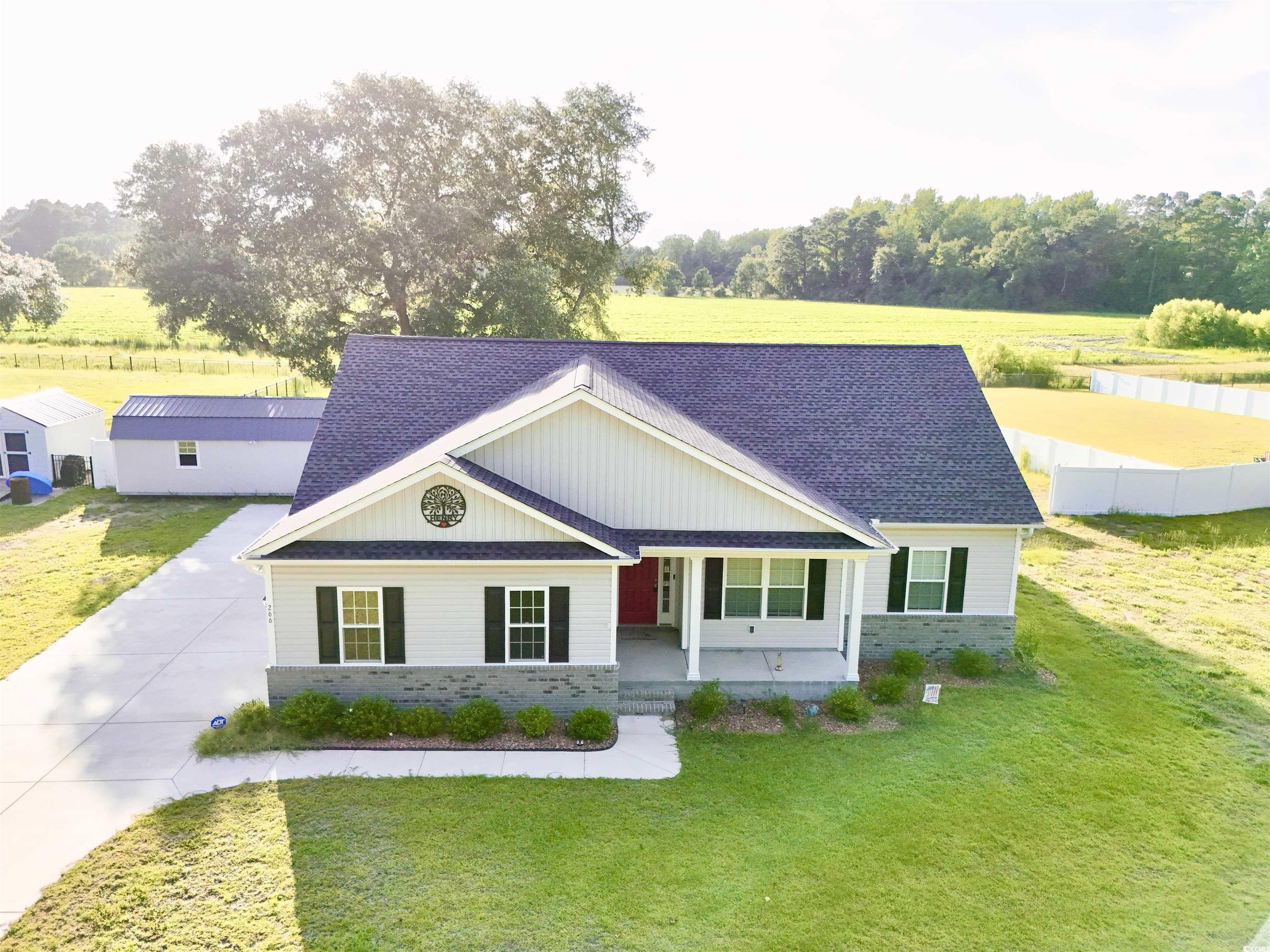 266 Ole Maple Street Loris, SC 29569 - Photo 2 of 30 View of front of house featuring roof with shingles, covered porch, concrete driveway, and brick siding