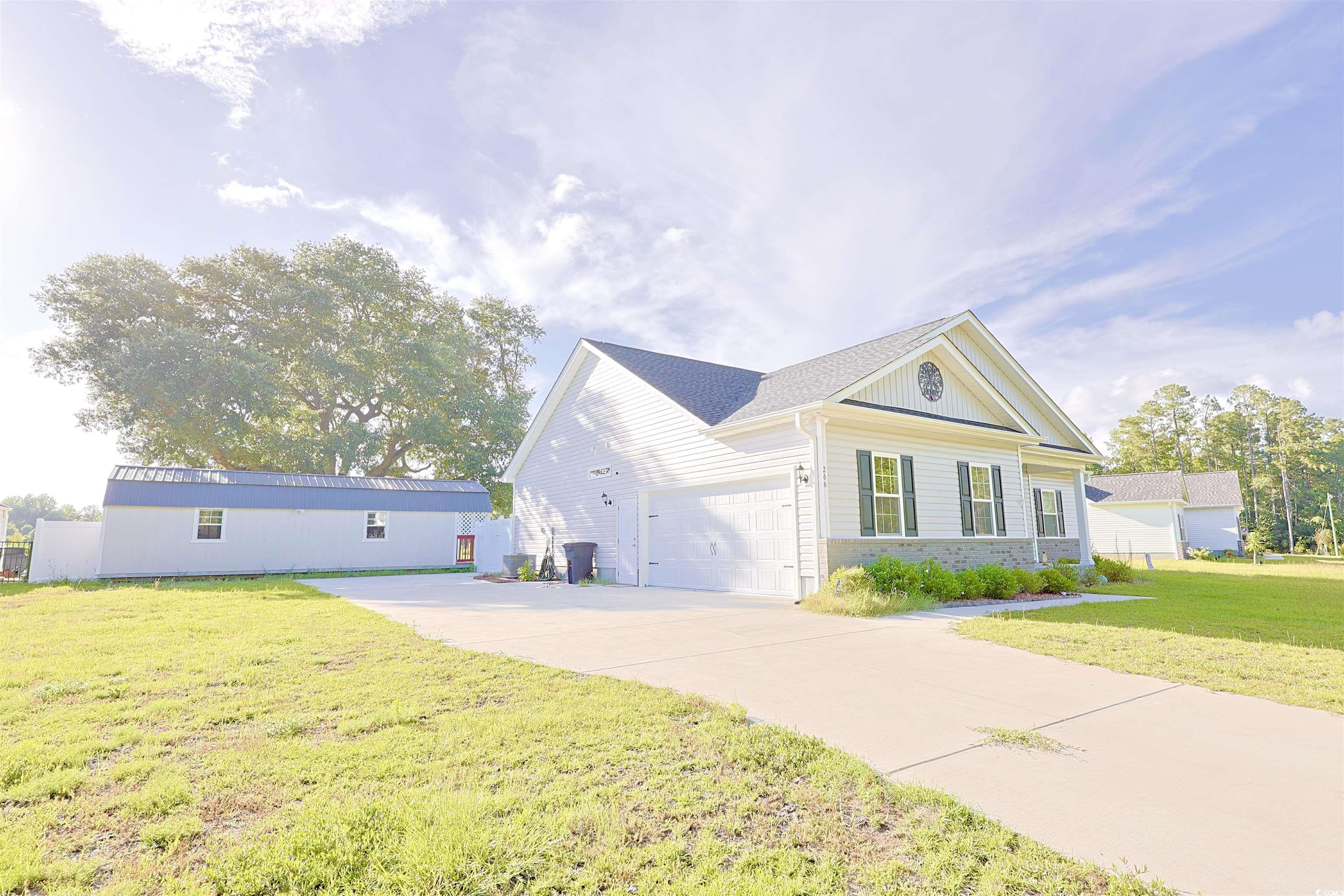 266 Ole Maple Street Loris, SC 29569 - Photo 30 of 30 View of front of home with a front yard, an attached garage, concrete driveway, and brick siding
