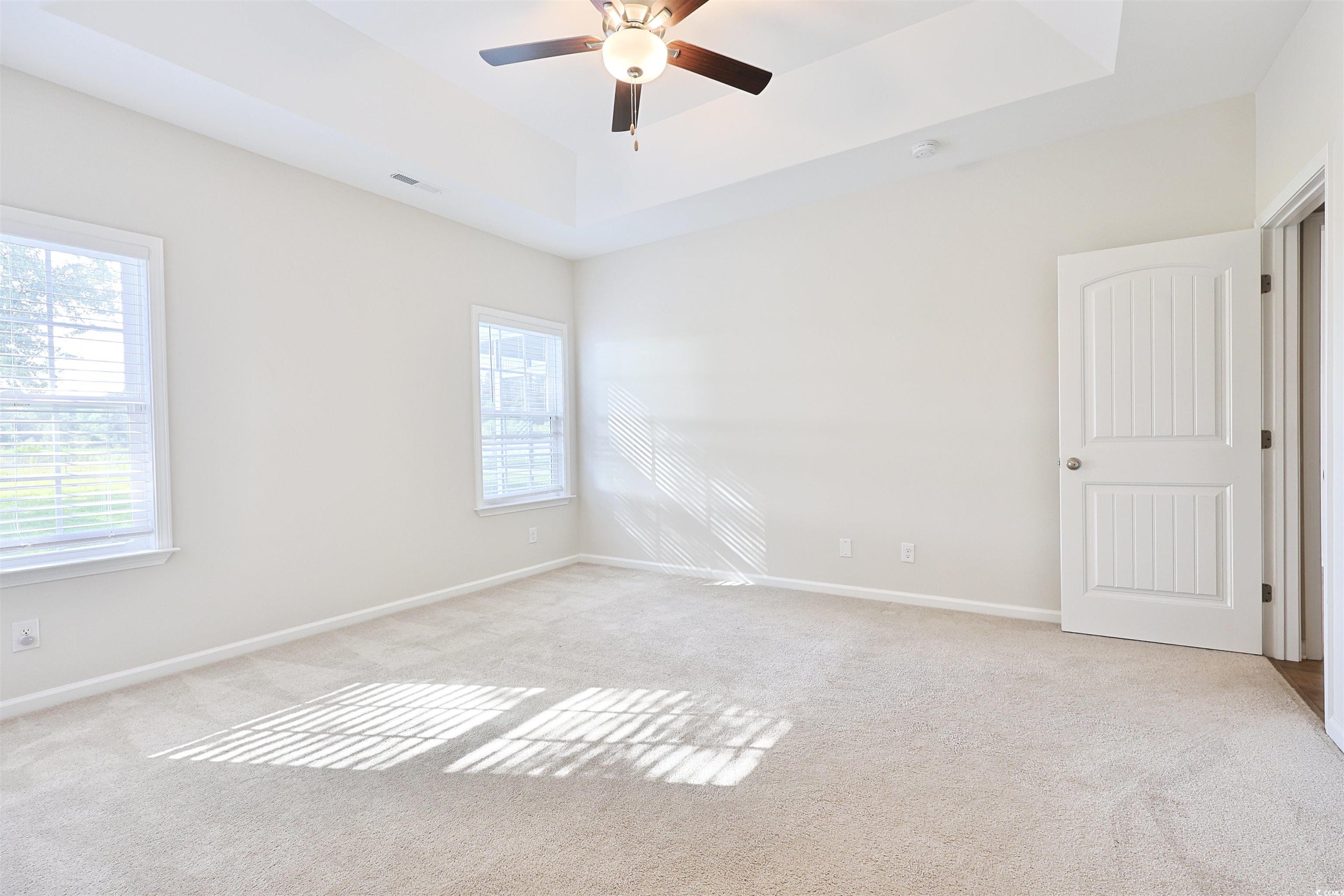266 Ole Maple Street Loris, SC 29569 - Photo 10 of 30 Spare room with a tray ceiling, light carpet, and a ceiling fan