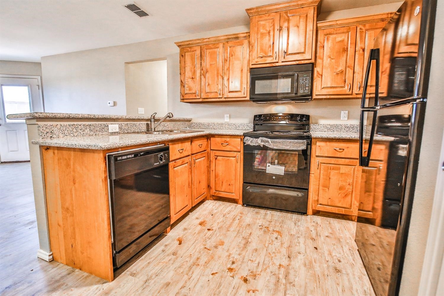 5710 Grinnell Street Lubbock, TX 79416 - Photo 6 of 21 a kitchen with stainless steel appliances granite countertop a stove a sink and a microwave