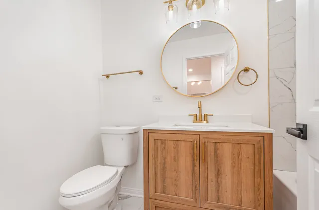 a bathroom with a toilet a sink and mirror