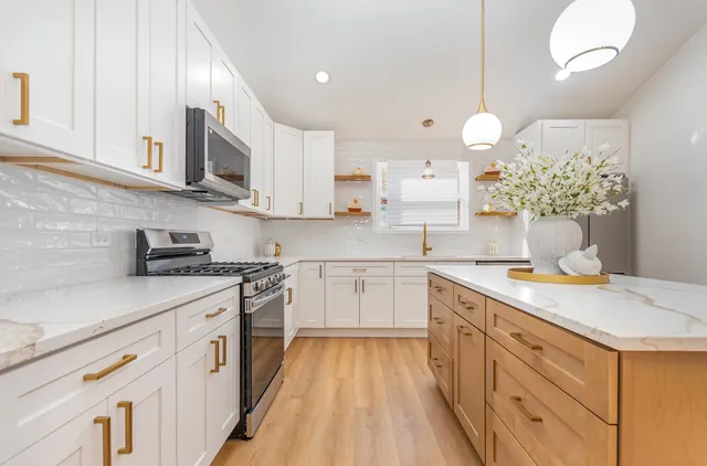 a kitchen with granite countertop white cabinets and white appliances