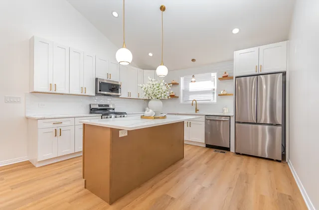 a kitchen with white cabinets and white appliances