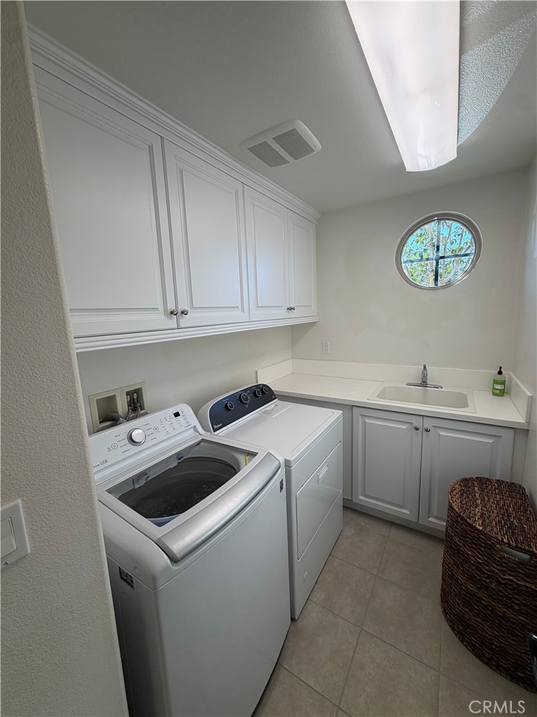 15 Galan Street Rancho Mission Viejo, CA 92694 - Photo 15 of 24 a utility room with cabinets washer and dryer