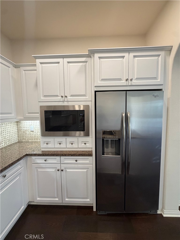 15 Galan Street Rancho Mission Viejo, CA 92694 - Photo 8 of 24 a kitchen with white cabinets and stainless steel appliances