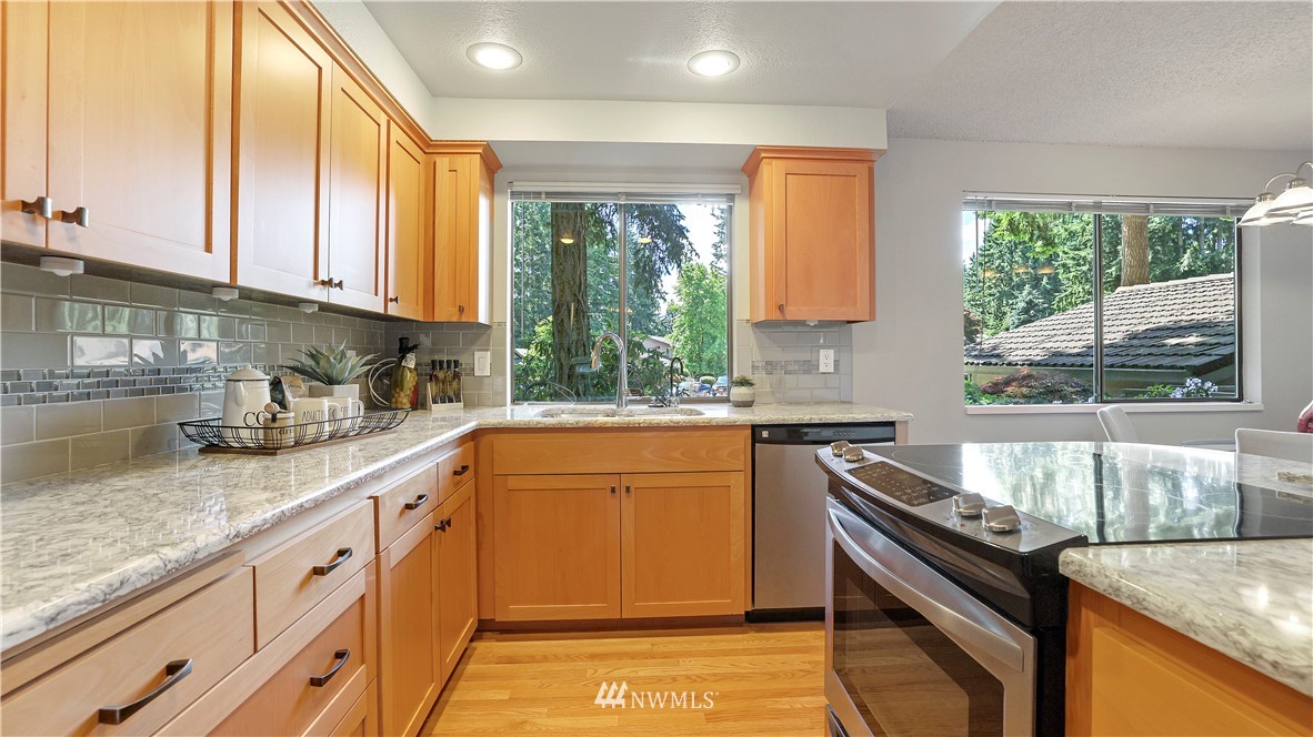 14101 148th Place Southeast Renton, WA 98059 - Photo 13 of 36 a kitchen with stainless steel appliances granite countertop a sink stove and cabinets