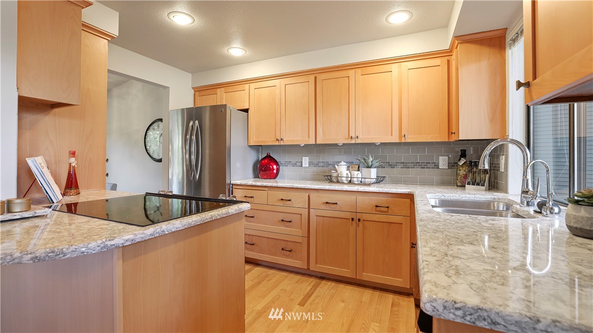 14101 148th Place Southeast Renton, WA 98059 - Photo 15 of 36 a kitchen with granite countertop a sink stainless steel appliances and cabinets