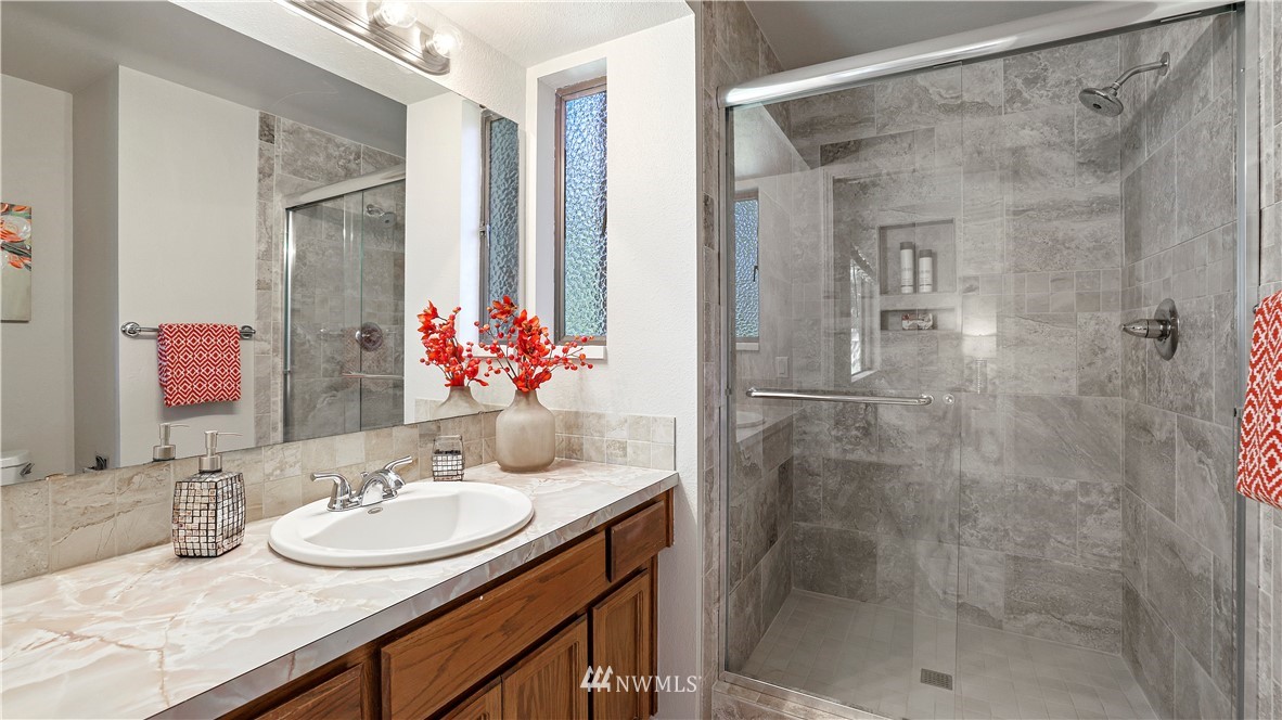 14101 148th Place Southeast Renton, WA 98059 - Photo 25 of 36 a bathroom with a granite countertop shower sink and mirror