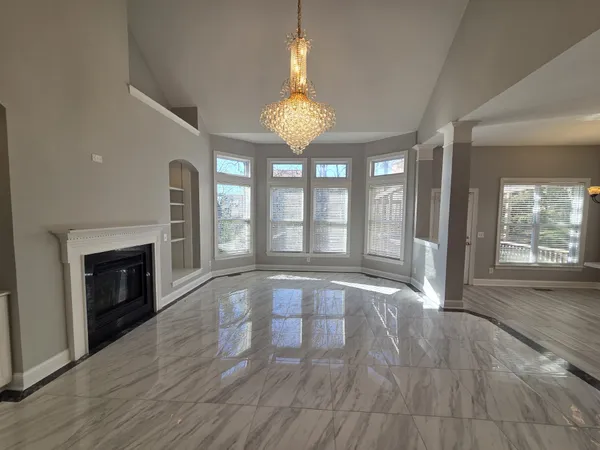 a view of an empty room with glass door and wooden floor