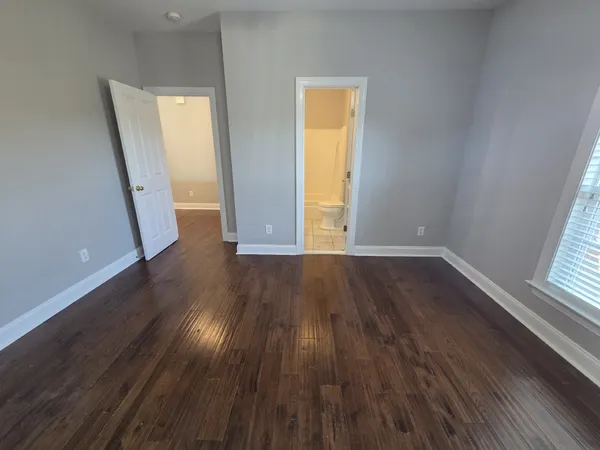 an empty room with wooden floor and door