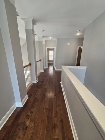 a view of a hallway with wooden floor and stairs