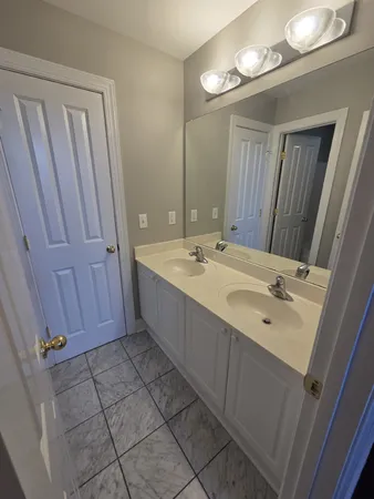 a bathroom with a double vanity sink and a mirror