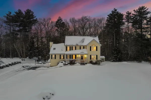 a view of a white house with a snow in front of yard