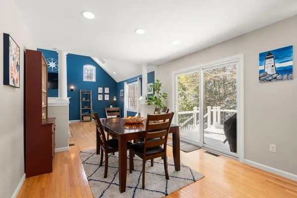 a open kitchen with stainless steel appliances granite countertop a sink dishwasher a stove a dining table and chairs with wooden floor