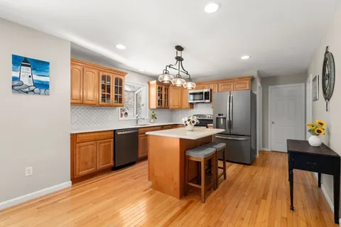 a kitchen with a stove top oven a clock and a window