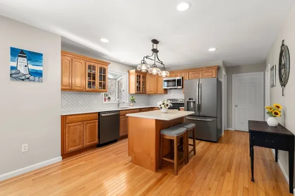 a kitchen with a stove top oven a clock and a window