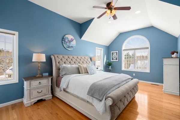 a bedroom with a large bed and a ceiling fan