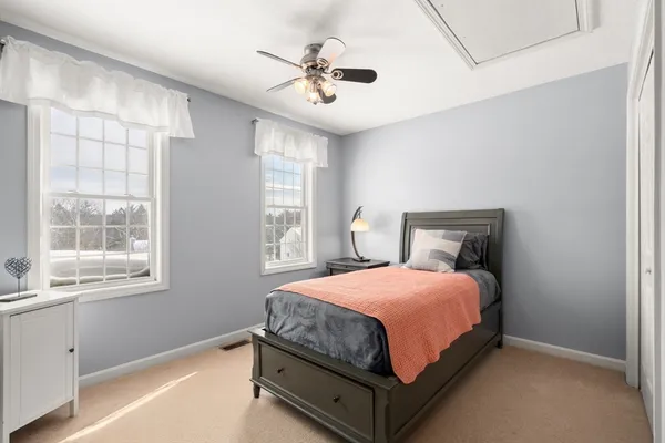 a bathroom with a granite countertop sink a toilet a mirror and window