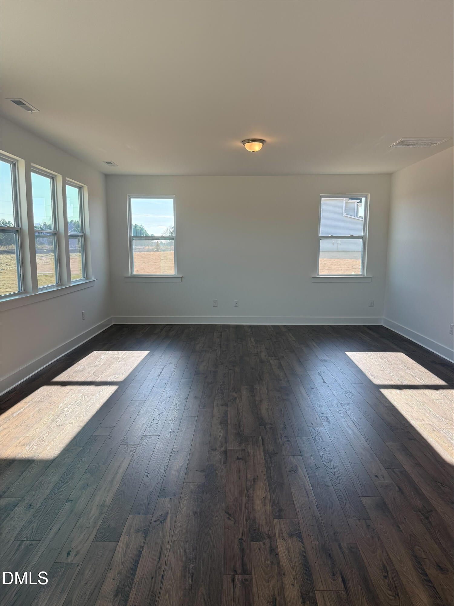 263 Kindness Drive Lillington, NC 27546 - Photo 15 of 37 an empty room with wooden floor and windows