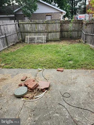 a view of a backyard with plants and wooden fence