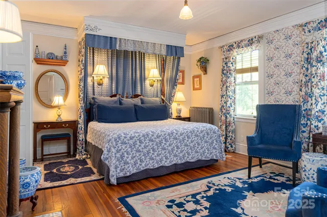 a bedroom with a bed a mirror on table and a window