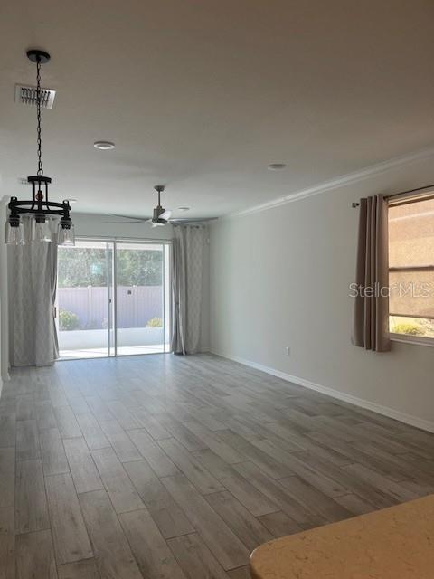 7947 Southwest 89th Loop Ocala, FL 34476 - Photo 6 of 25 a view of a room with wooden floor ceiling fan and window