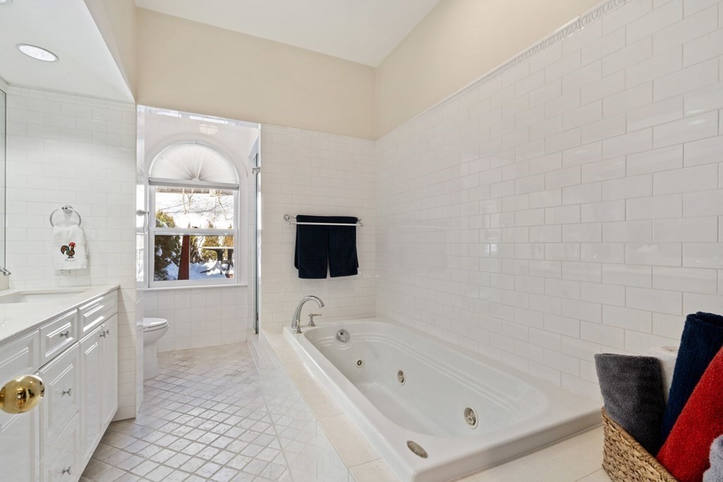 49 Rawson Road, Unit 49 Brookline, MA 02445 - Photo 21 of 42 a bathroom with a bathtub a mirror a sinks a toilet and a shower