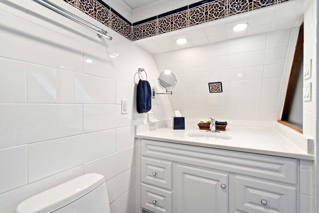 49 Rawson Road, Unit 49 Brookline, MA 02445 - Photo 29 of 42 a bathroom with a sink a toilet and mirror