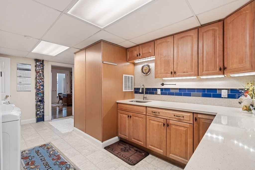 49 Rawson Road, Unit 49 Brookline, MA 02445 - Photo 38 of 42 a kitchen with stainless steel appliances granite countertop a refrigerator a sink and dishwasher with wooden cabinets