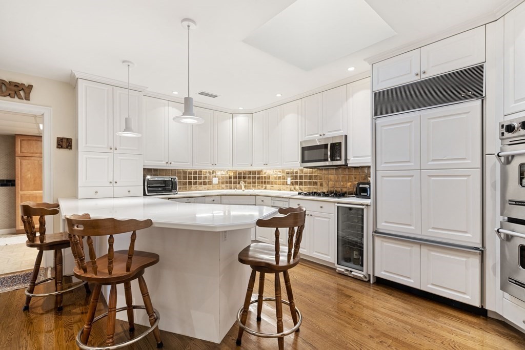 49 Rawson Road, Unit 49 Brookline, MA 02445 - Photo 39 of 42 a kitchen with stainless steel appliances white cabinets and wooden floor