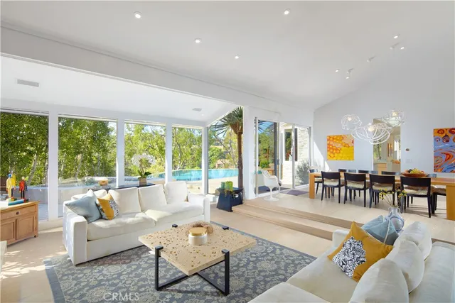 a living room with furniture and floor to ceiling windows
