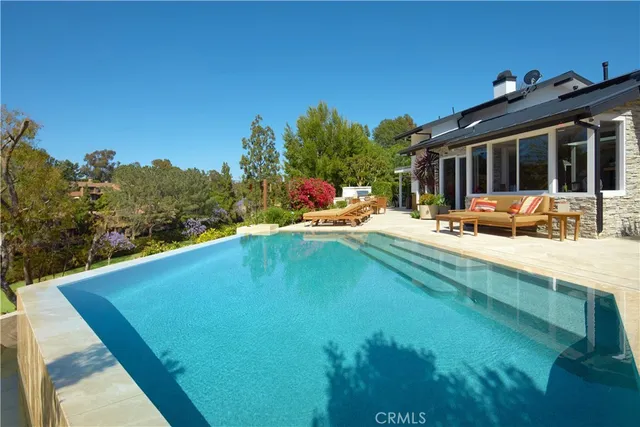 a view of swimming pool with outdoor seating and a garden