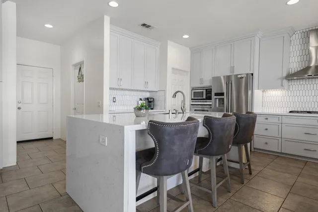 a kitchen with refrigerator cabinets dining table and chairs