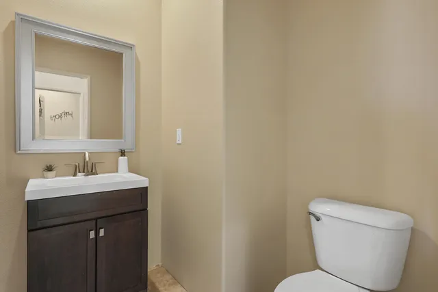 a bathroom with a toilet sink and mirror