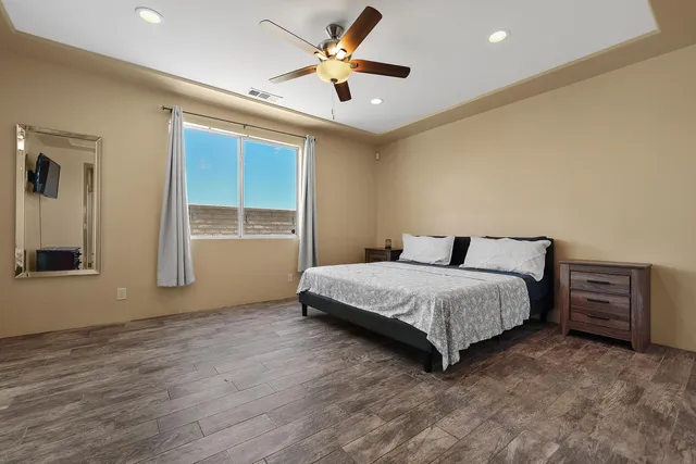 a spacious bedroom with a bed and a chandelier