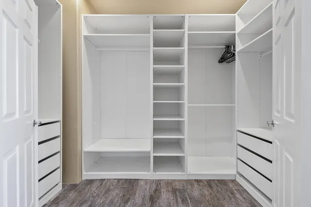 a view of walk in closet with empty racks