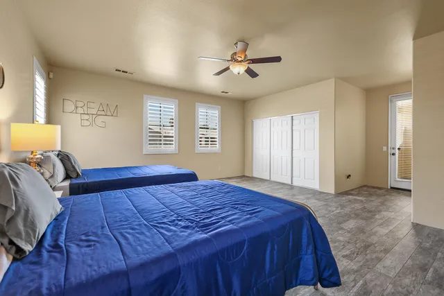 a bedroom with a large bed chandelier and a window