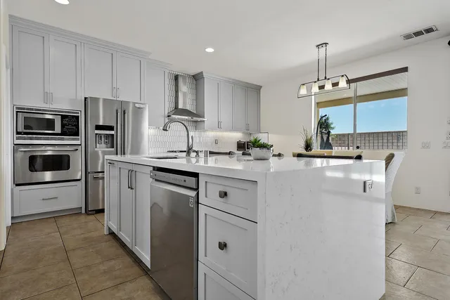 a kitchen with stainless steel appliances a refrigerator sink and microwave