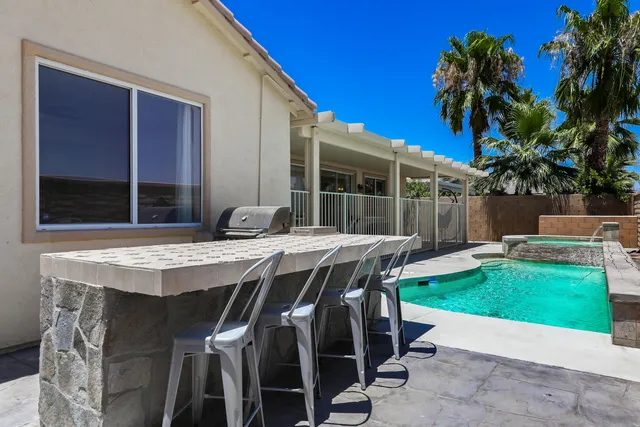 a patio with a table and chairs and potted plants