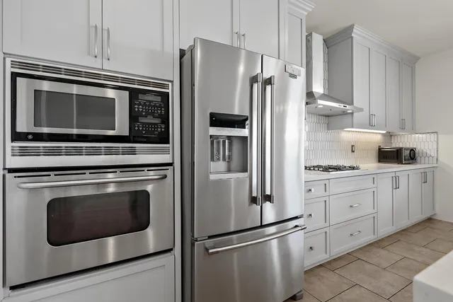 a kitchen with granite countertop cabinets stainless steel appliances and wooden floor