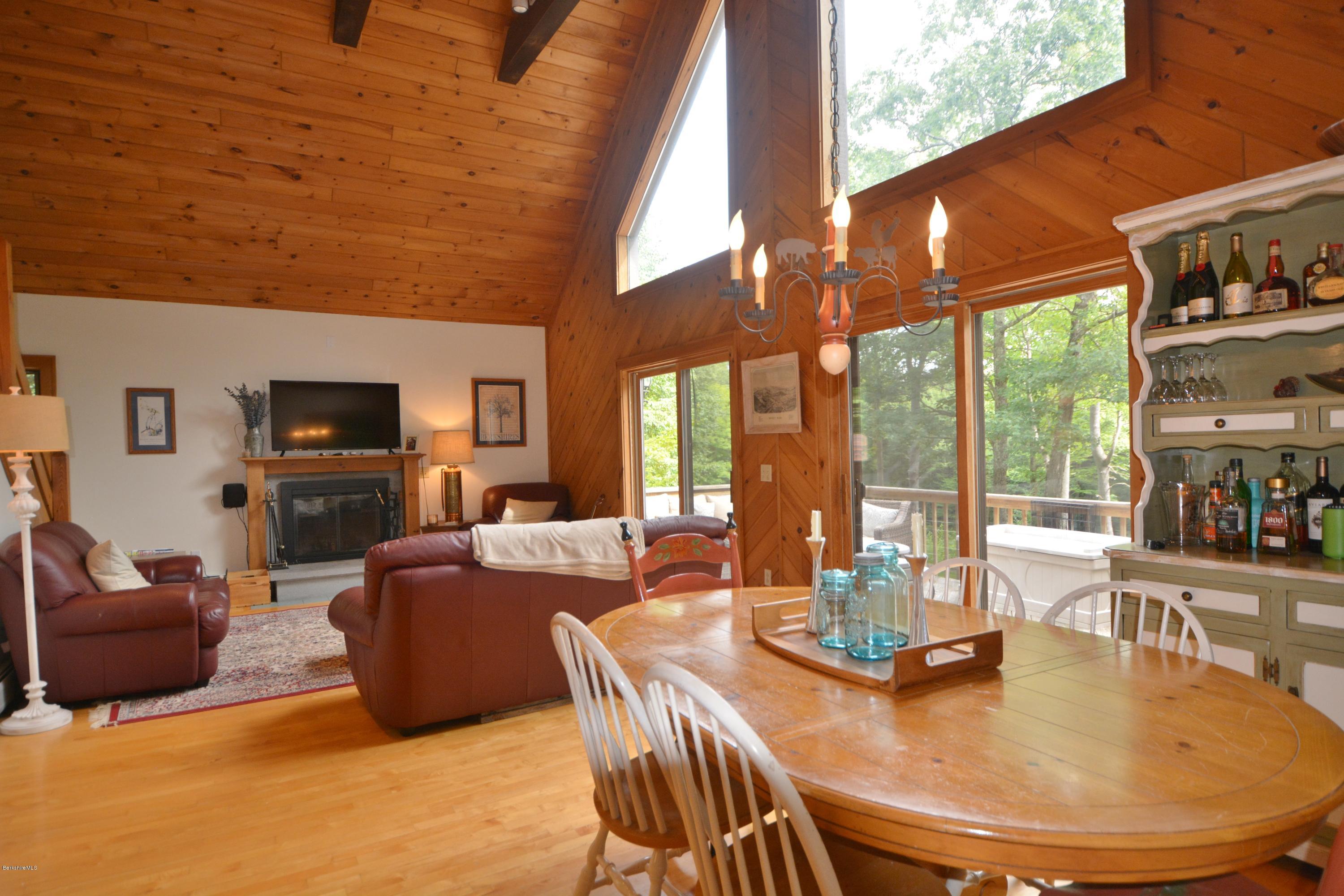70 Rainbow Road Otis, MA 01029 - Photo 4 of 18 a dining room with furniture a large window and a fireplace