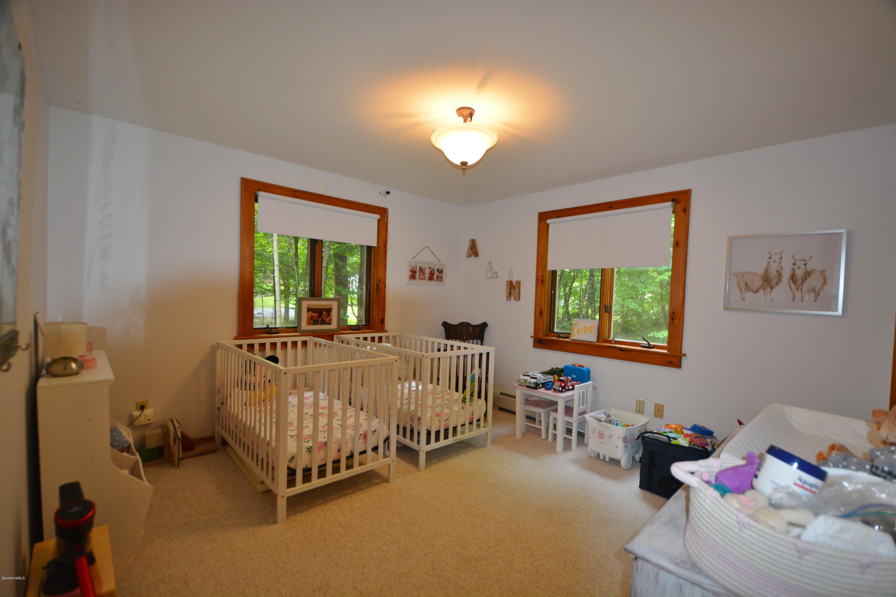 70 Rainbow Road Otis, MA 01029 - Photo 7 of 18 a bedroom with a bed and a chandelier