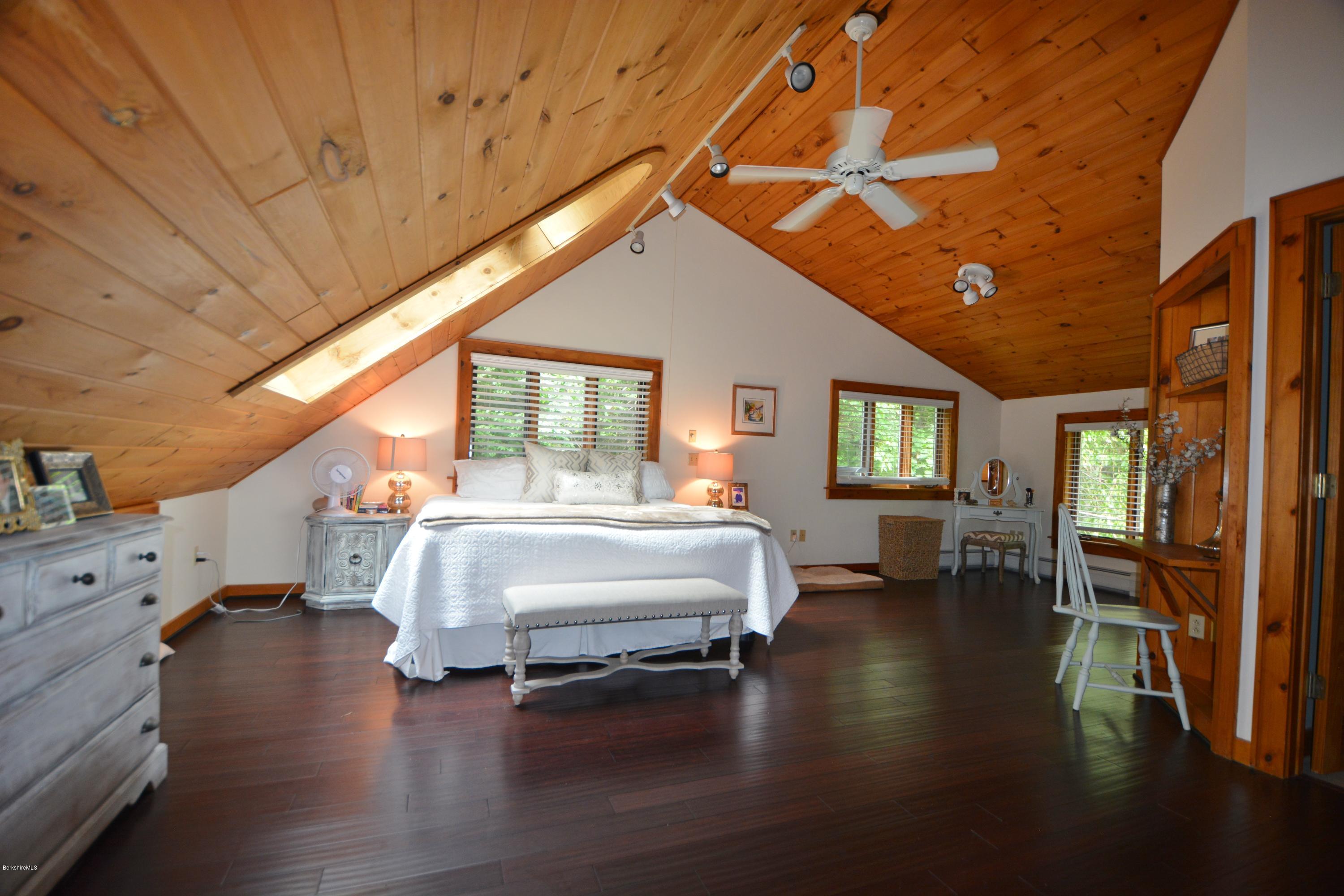 70 Rainbow Road Otis, MA 01029 - Photo 10 of 18 a spacious bedroom with a large bed and a chandelier