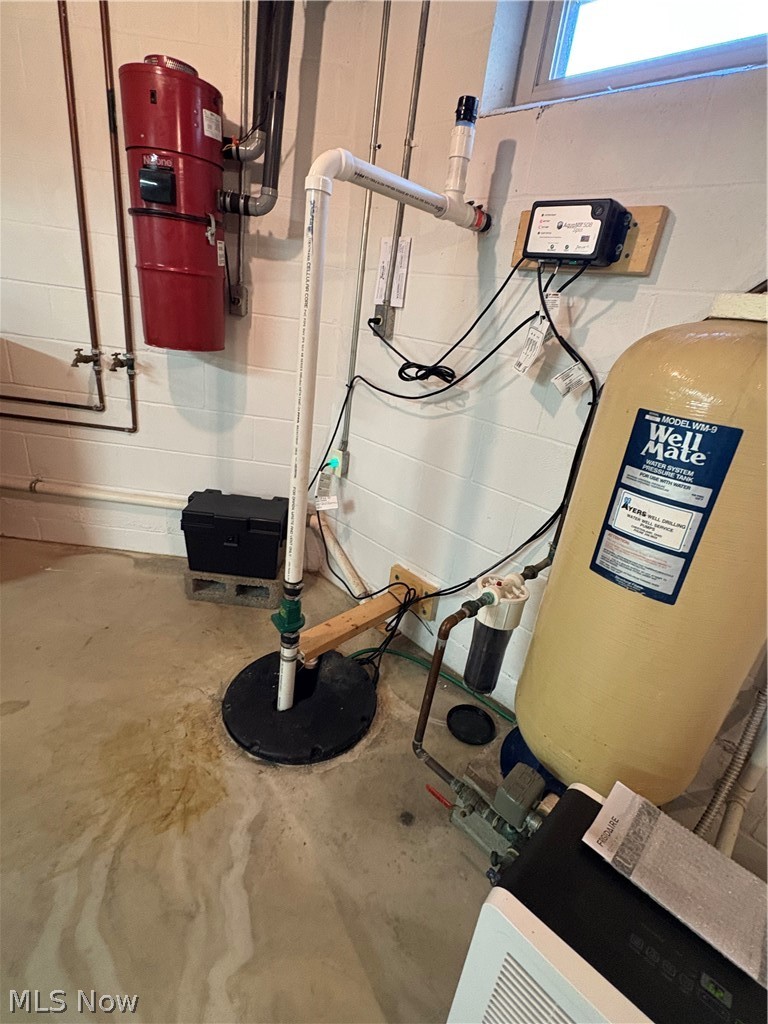 6475 Taylor Road Painesville, OH 44077 - Photo 15 of 23 Basement utility area featuring a central vacuum system, a water softening system, and a sump pump