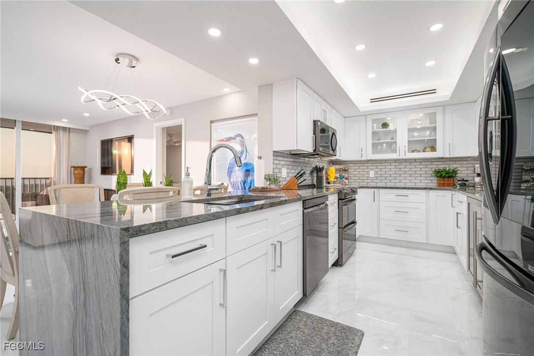 17 Bluebill Avenue, Unit 903 Naples, FL 34108 - Photo 8 of 33 a kitchen with white cabinets and white appliances