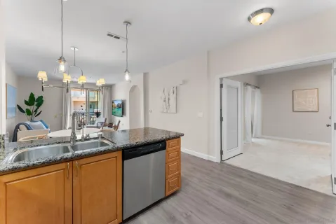 a kitchen with granite countertop a sink a counter top space and living room view