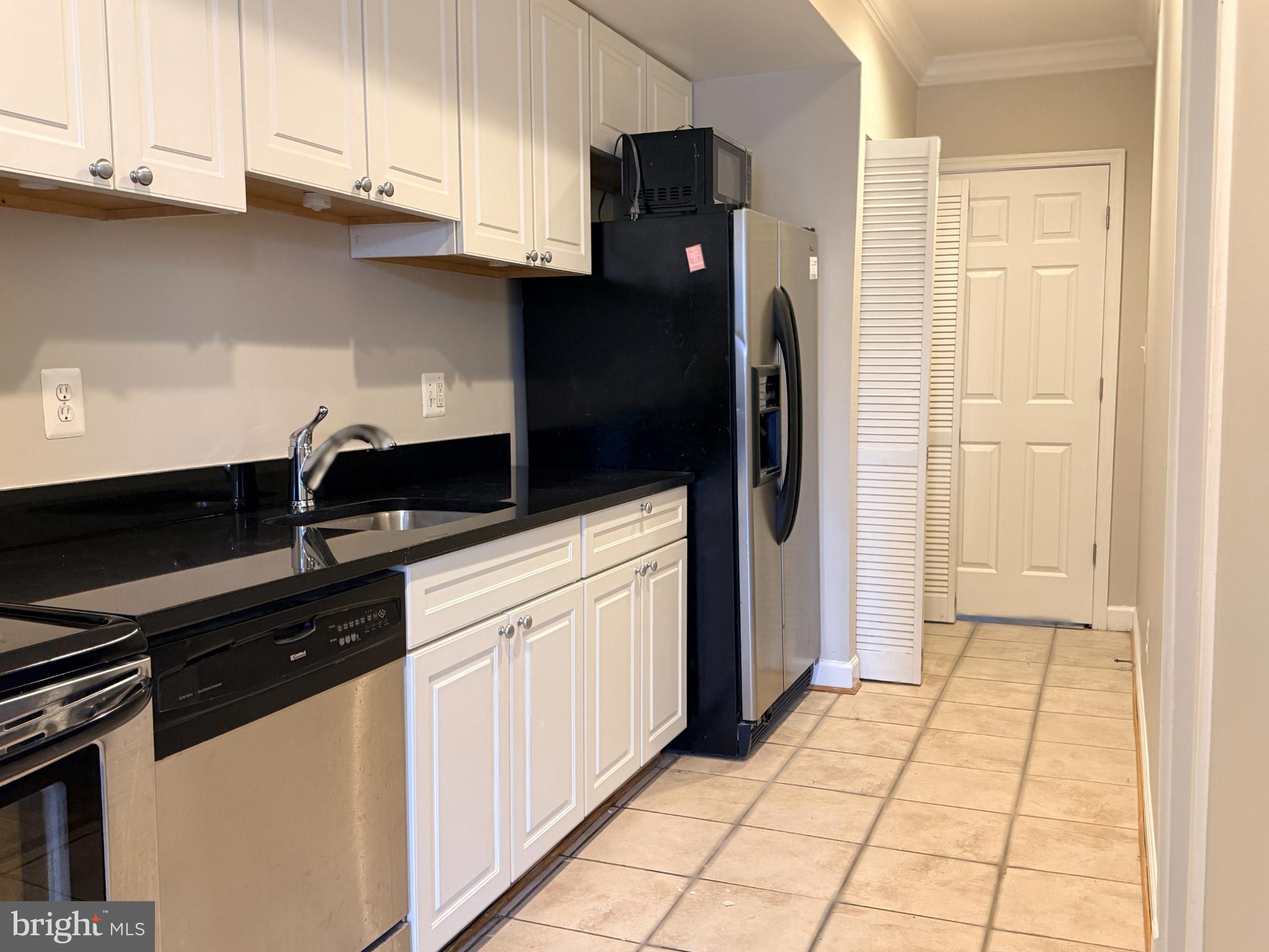 1246 Queen Street Northeast, Unit 2 Washington, DC 20002 - Photo 6 of 23 a kitchen with granite countertop a refrigerator and a sink