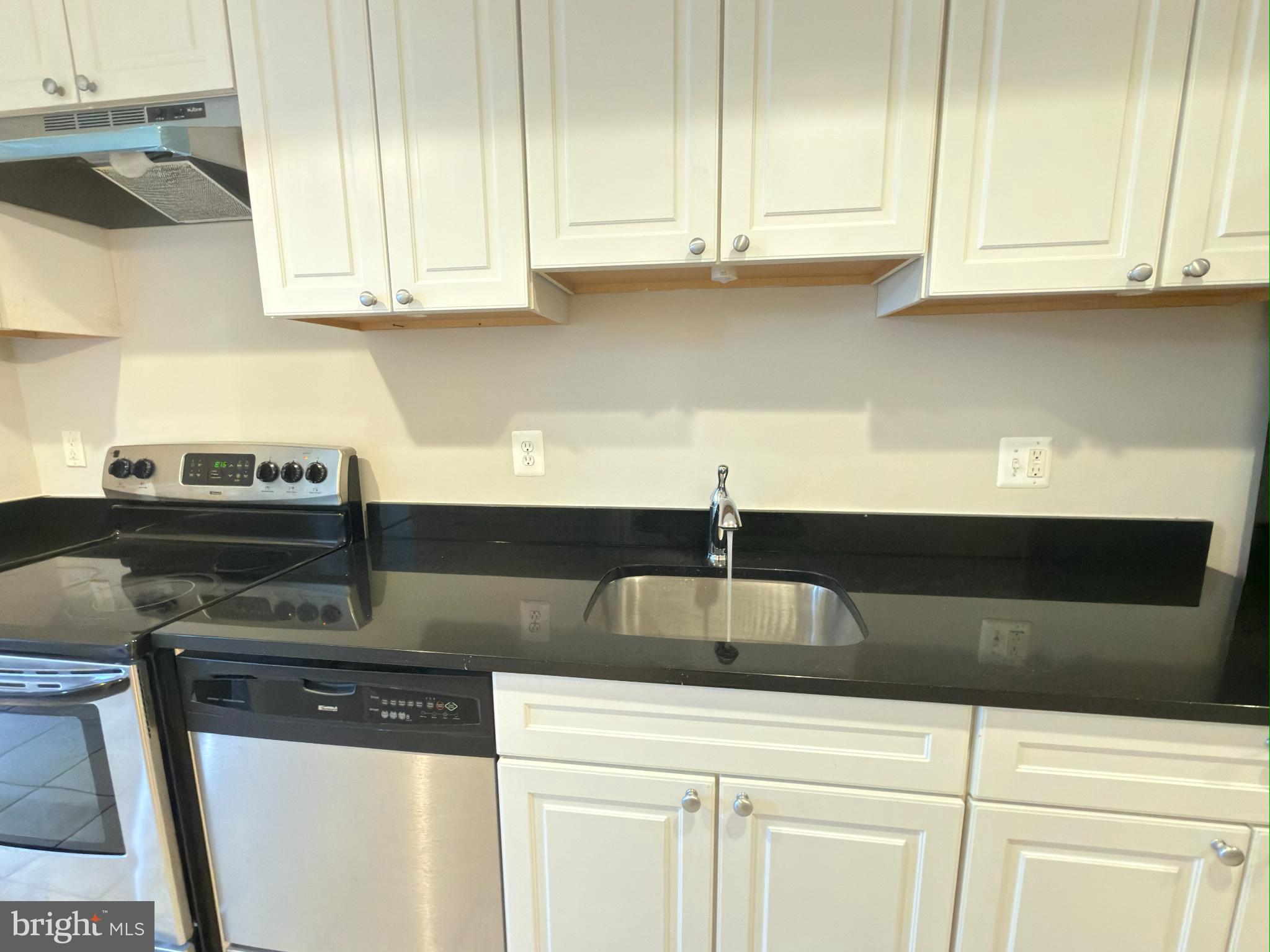 1246 Queen Street Northeast, Unit 2 Washington, DC 20002 - Photo 9 of 23 a kitchen with stainless steel appliances granite countertop a sink a stove and cabinets