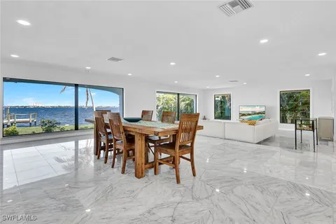 a living room with furniture and a large window with kitchen view