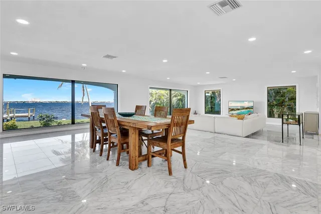 a living room with furniture and a large window with kitchen view